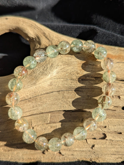 A 9mm bead stretch bracelet made of clear Brazilian macrocrystalline quartz heavily included with natural black and red rutile crystals.