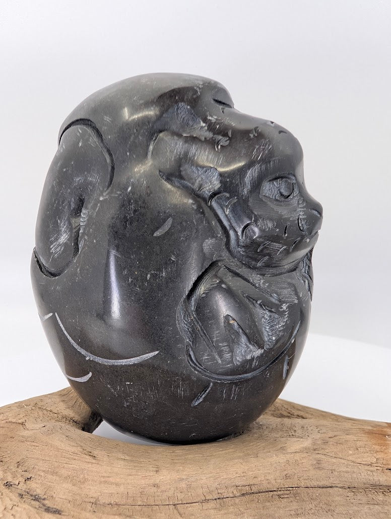 Angled view of the Black Soapstone Dragon carving emphasizing the smooth, fluid lines and traditional folk style.