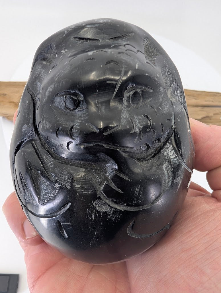 A Black Soapstone Dragon held in hand to provide a scale reference of the 105mm AAA grade carving.