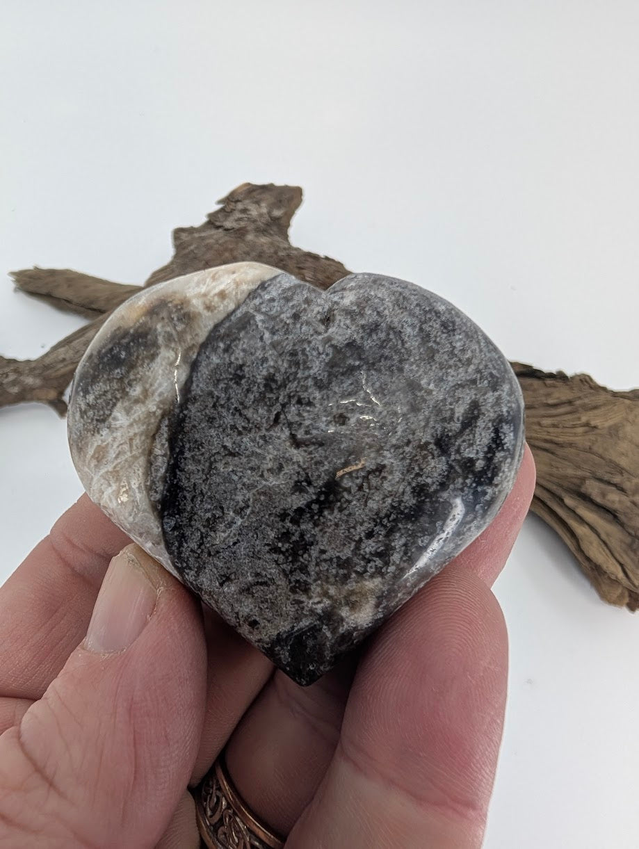 Hand holding a 110g Black Banded Sphalerite heart showing size and gloss.