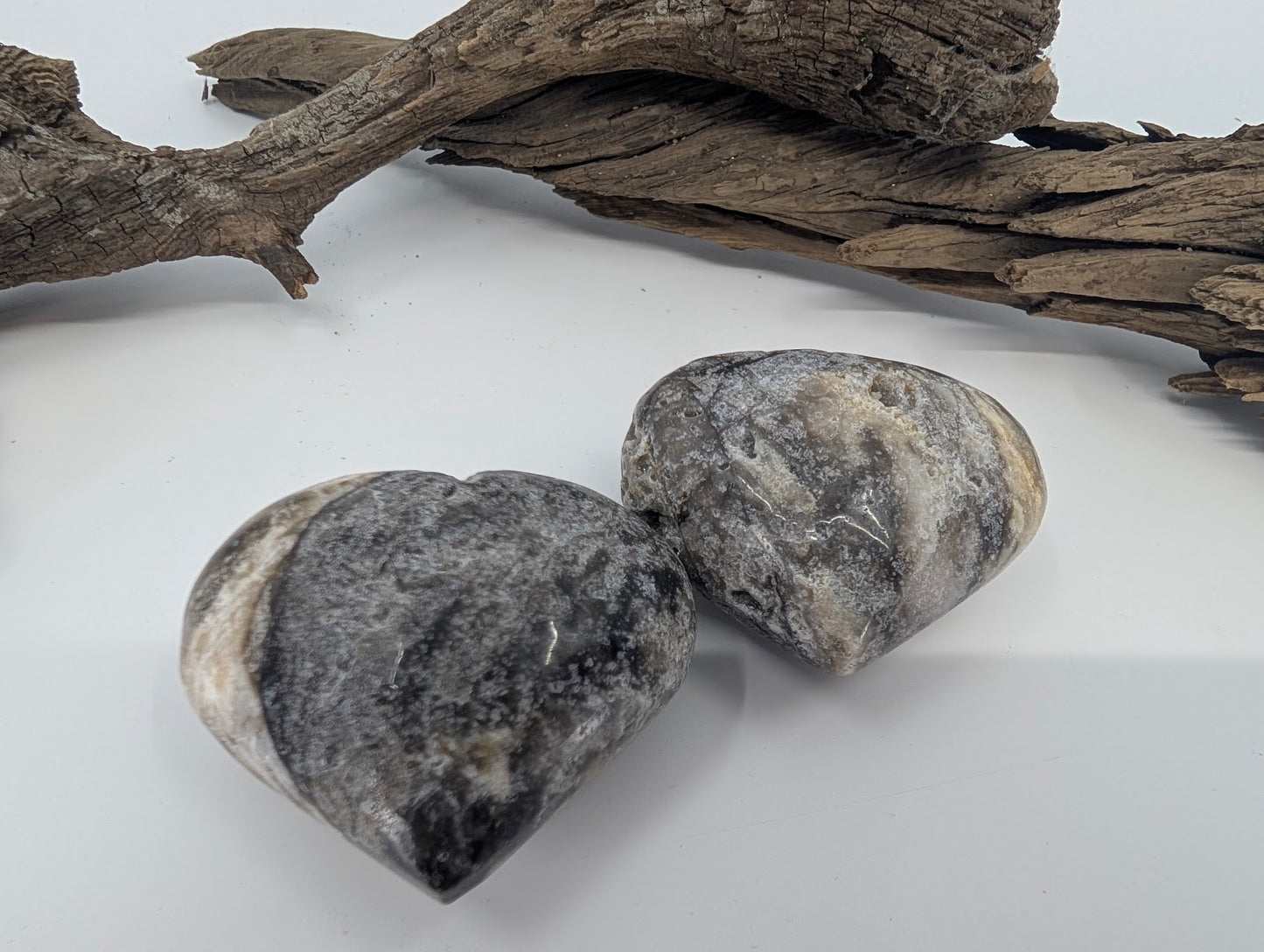 Pair of polished Black Sphalerite hearts showing cream and grey banding.