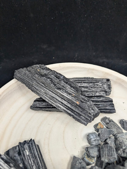 Top-down view of elongated Black Tourmaline rods highlighting the prismatic crystal habit and naturally fractured ends.