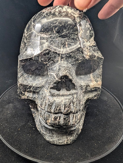 Close-up of face and teeth carving — polished black tourmaline