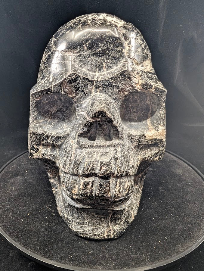 Front view of Black Tourmaline Skull — 4 kg polished carving with natural striations