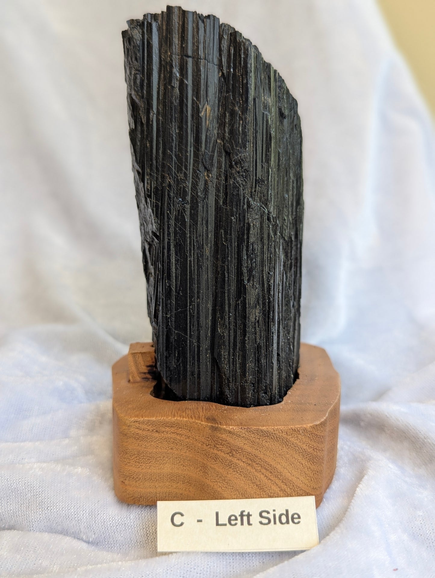 left side of 1.11kg large raw Black Tourmaline tower showing massive crystal growth on stand.