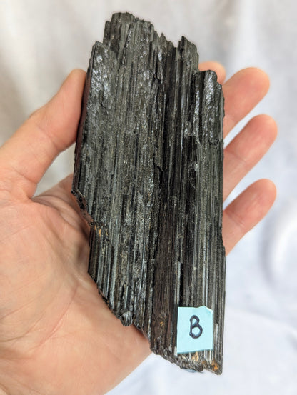 Hand held view of 435g raw Black Tourmaline tower.