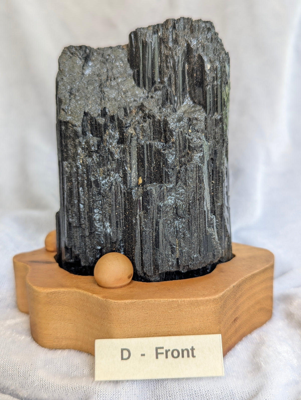 680g raw Black Tourmaline tower featuring sharp terminations on wooden base.