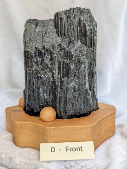 680g raw Black Tourmaline tower featuring sharp terminations on wooden base.