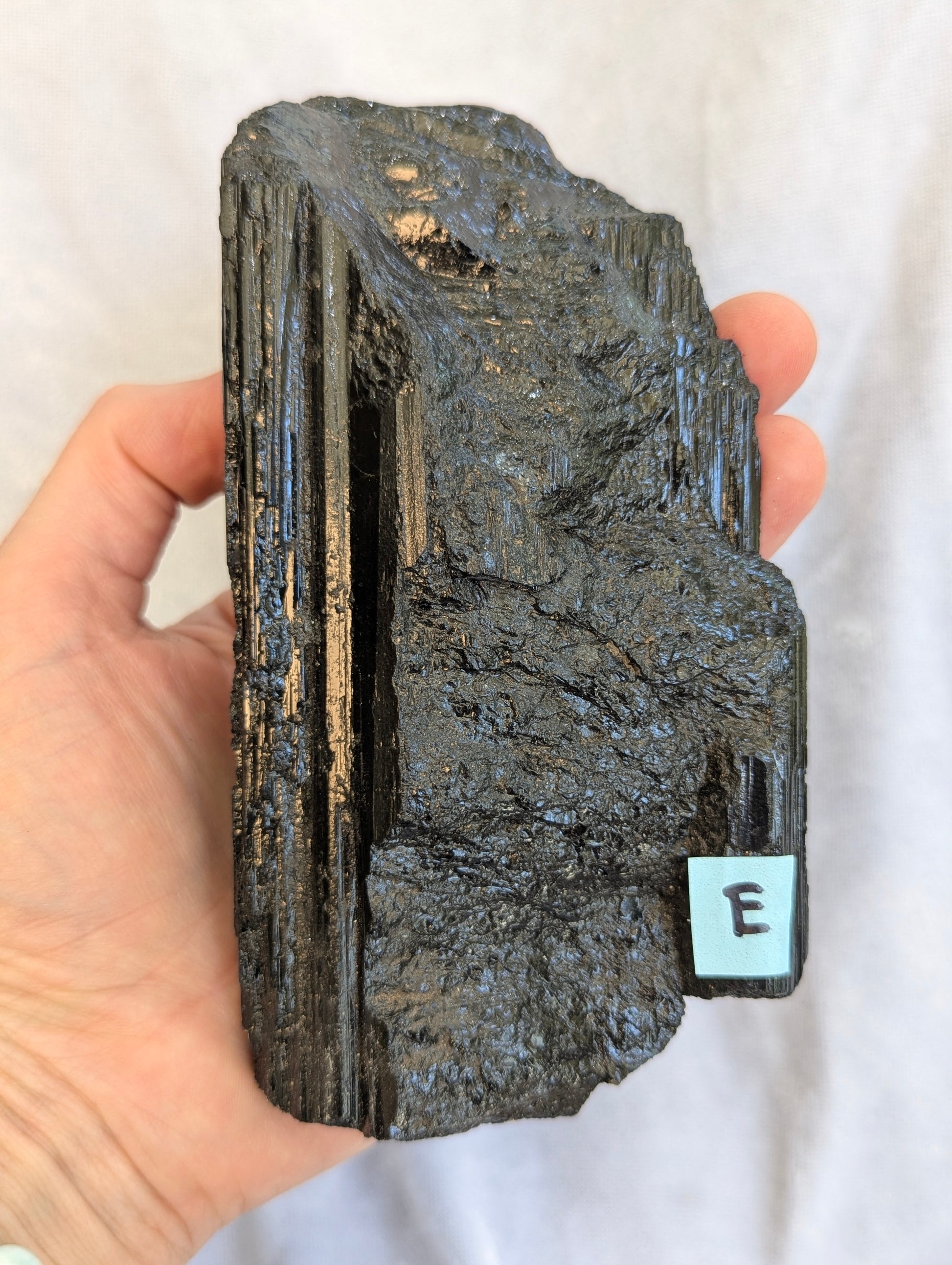 Hand Held view of 700g raw Black Tourmaline tower.