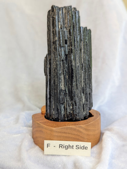 Side view of 765g raw Black Tourmaline tower on custom wooden base.