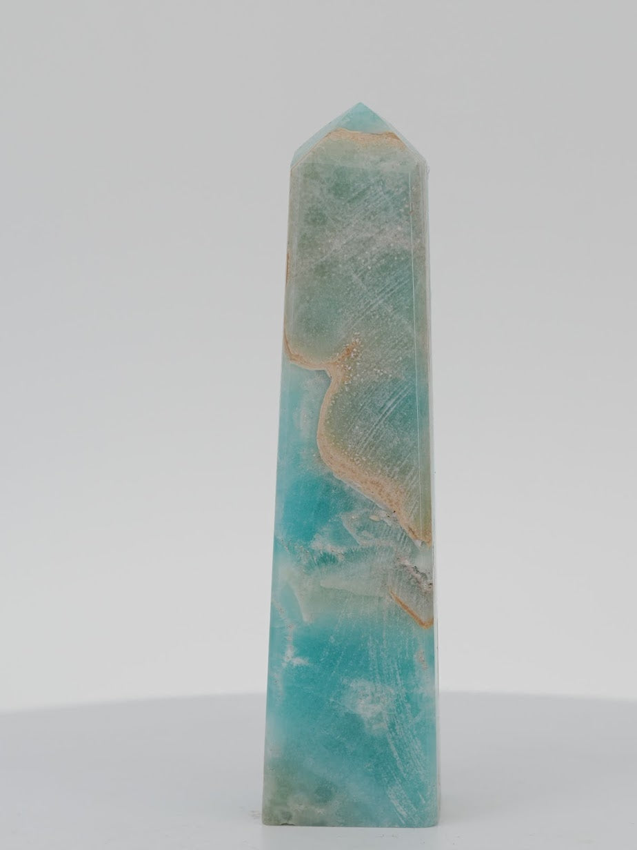 Polished Blue Aragonite tower featuring vibrant seafoam blue and tan layers with natural surface textures.