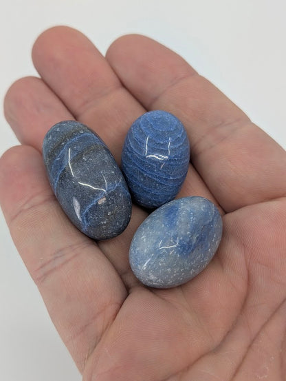 Three Blue Aventurine tumbled stones shown in hand for size reference