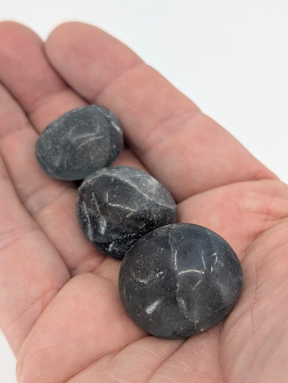 Blue Fluorite tumbled stones in hand for size reference