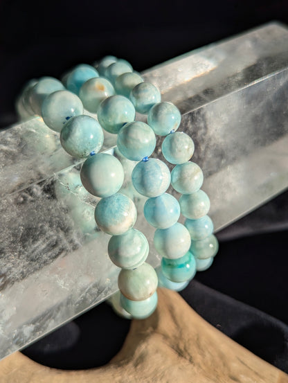 Premium blue hemimorphite beaded stretch bracelet worn on the wrist to demonstrate scale, light refraction, and bead uniformity.