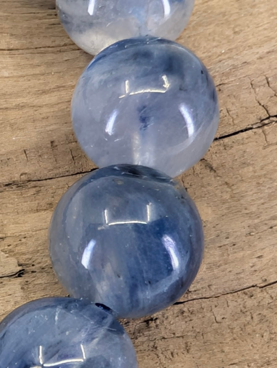 Macro view of Brazilian Blue Kyanite beads showing high-gloss polish and authentic mineral veiling