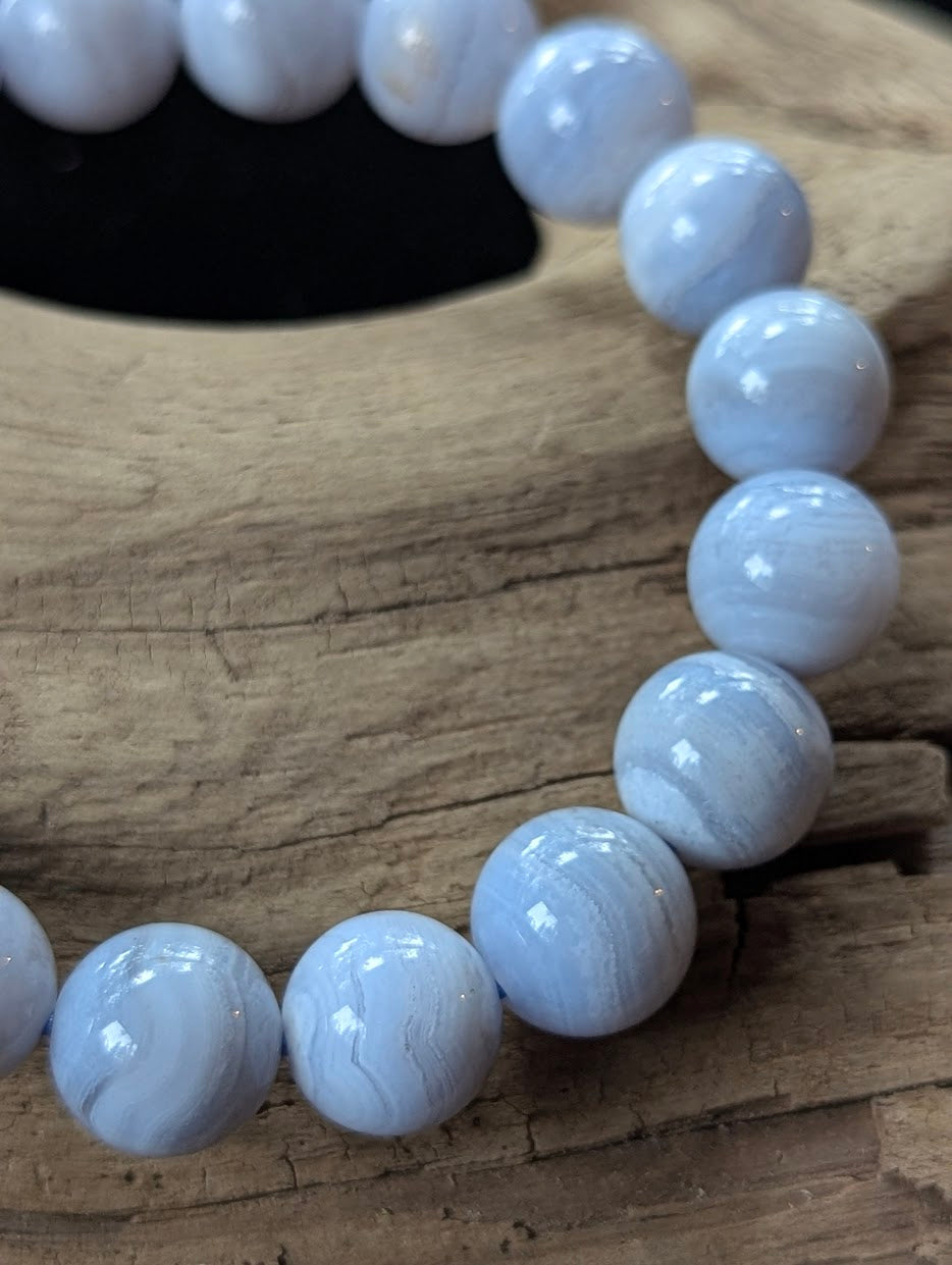 Macro view of a 10mm Blue Lace Agate bracelet emphasizing Museum Grade chalcedony banding and high polish.