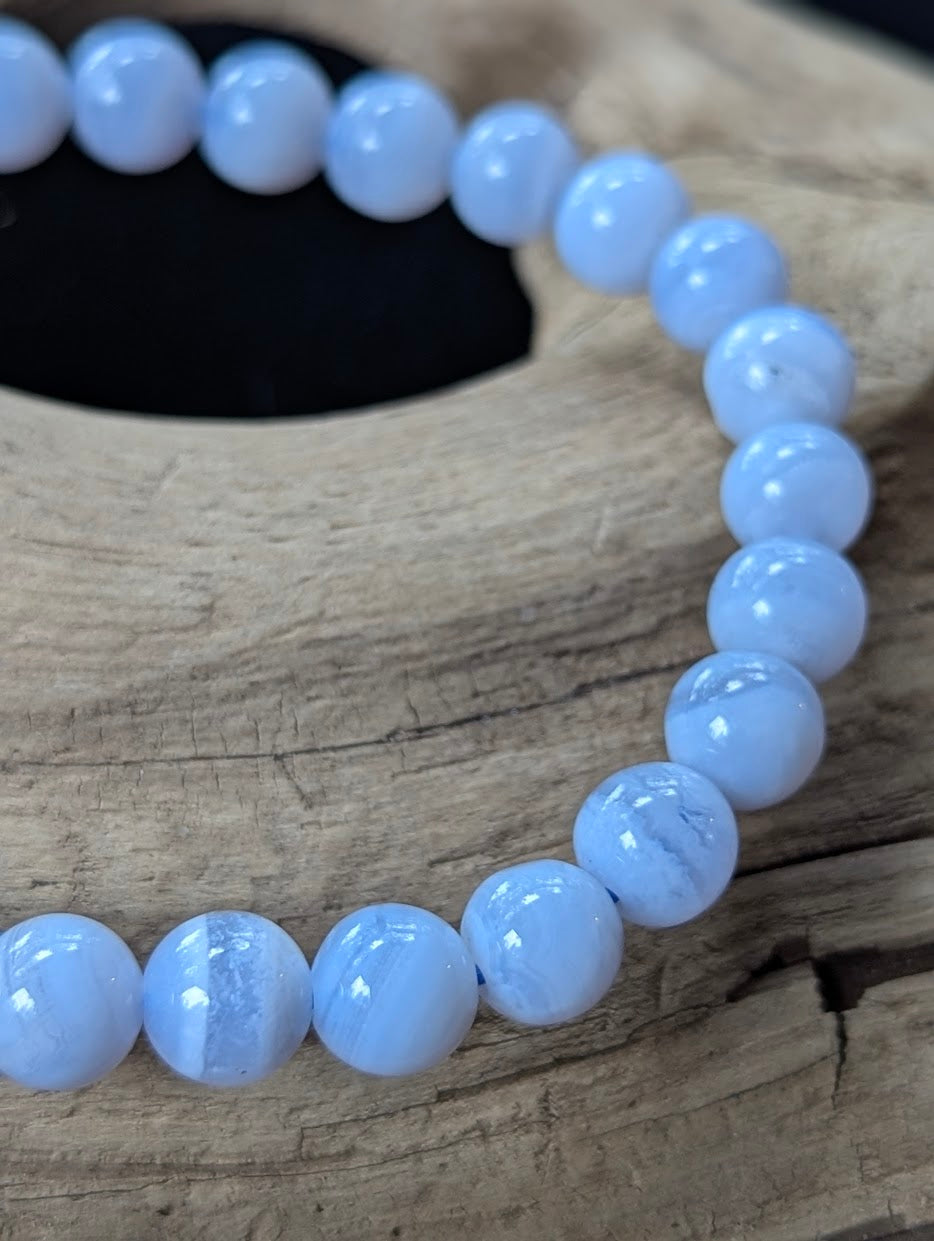 Close-up of a 7mm Blue Lace Agate bracelet highlighting crisp white chalcedony banding over pale blue.
