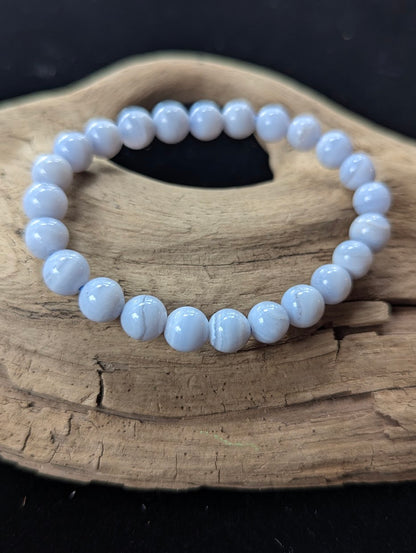 8mm natural Blue Lace Agate bead bracelet from Namibia displayed on driftwood.