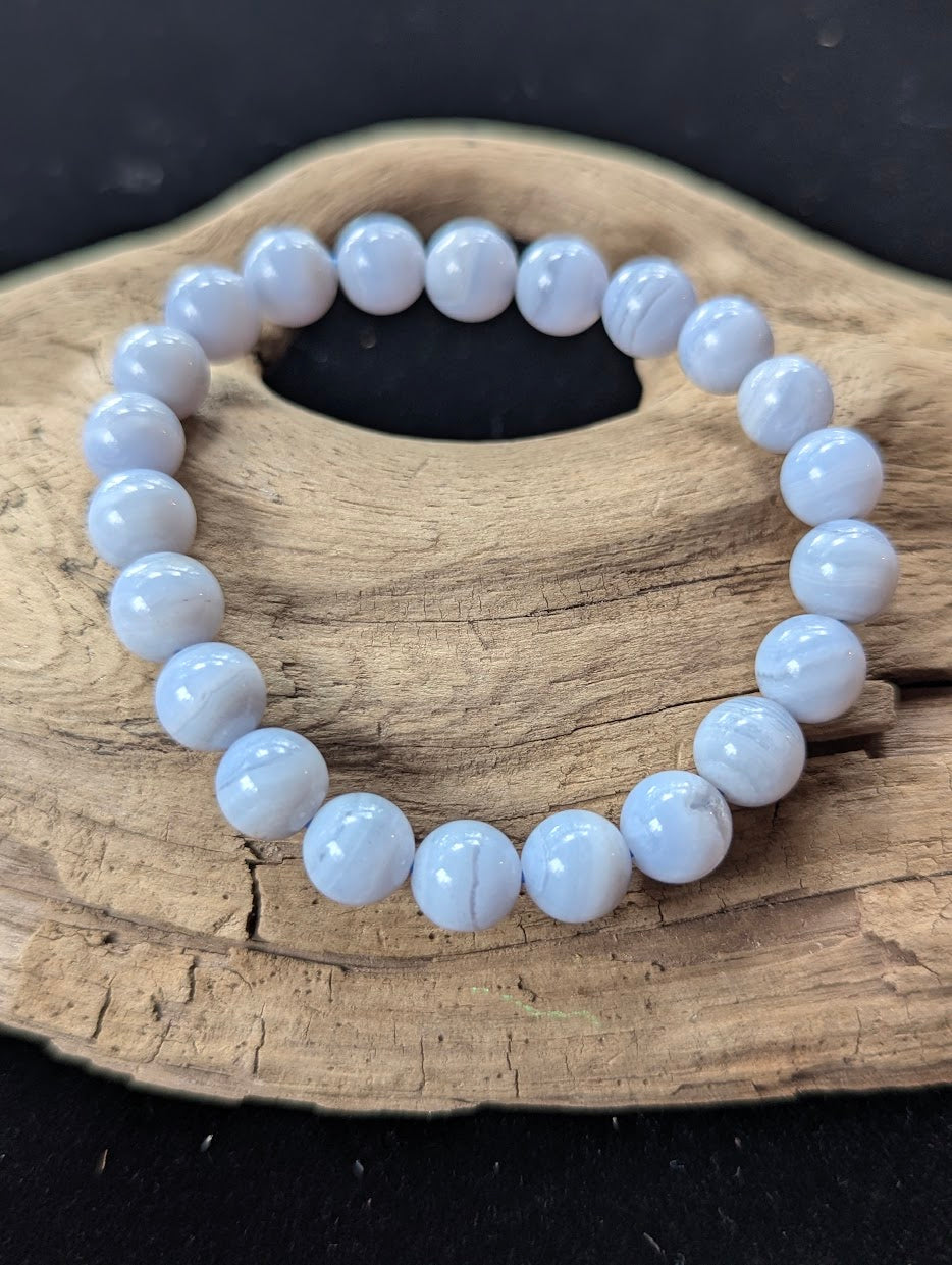 9mm natural Blue Lace Agate bead bracelet from Namibia displayed on driftwood.
