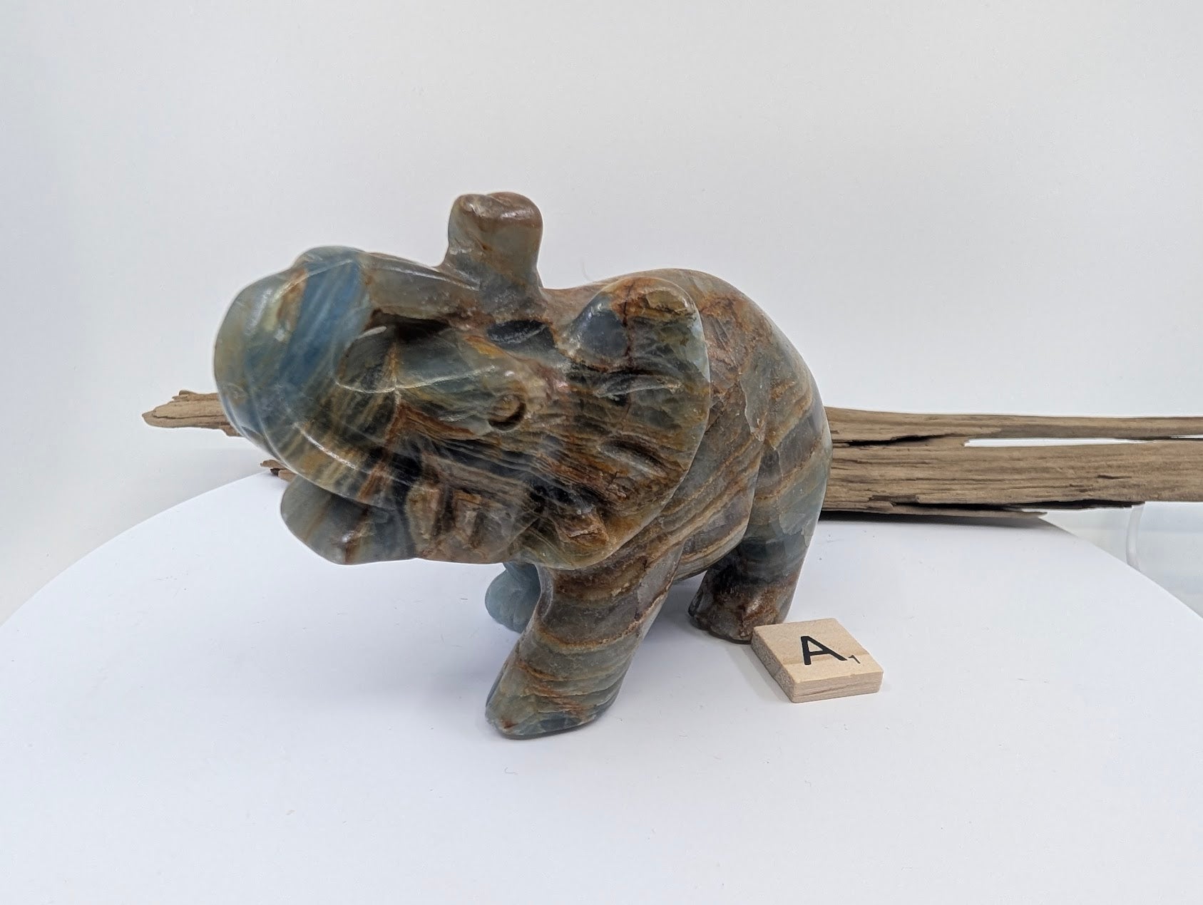 Detailed front-facing view of Blue Onyx elephant A1 highlighting the trunk, tusks, and silk-luster polish.