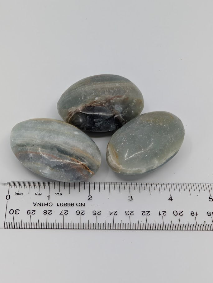 Blue Onyx palm stones with measuring scale showing approximate size and smooth finish