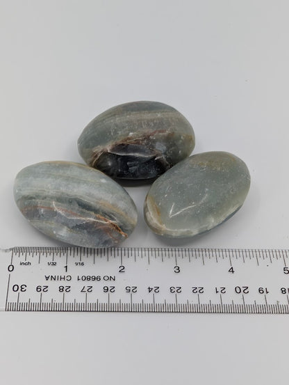 Blue Onyx palm stones with measuring scale showing approximate size and smooth finish