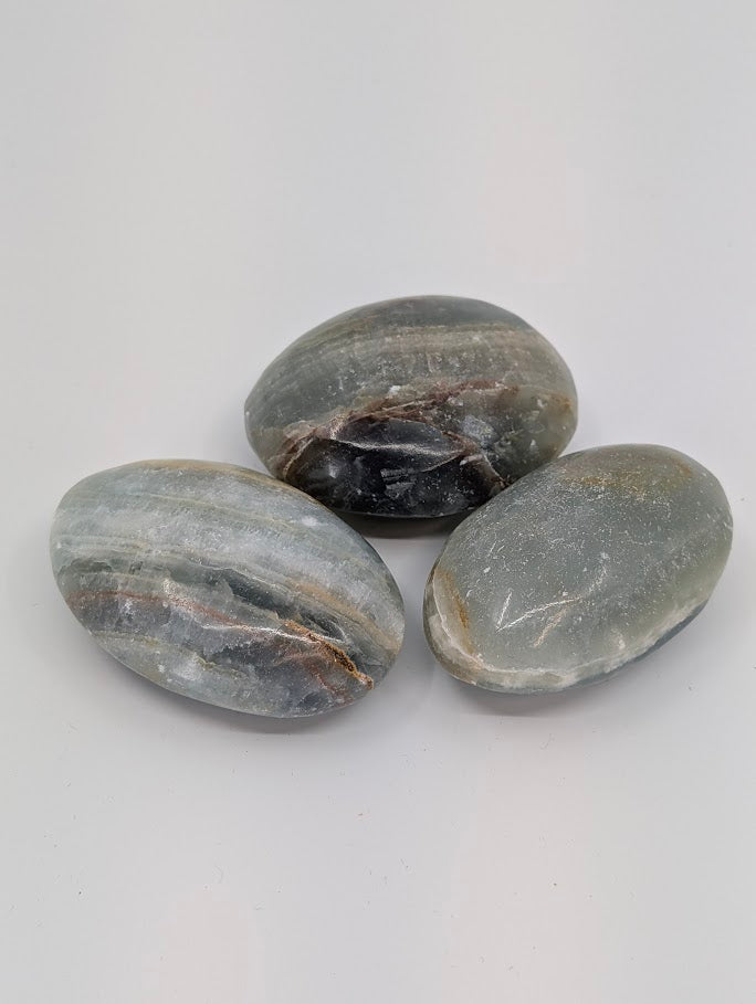 Blue Onyx palm stones showing grey-blue banding and polished oval shape front view