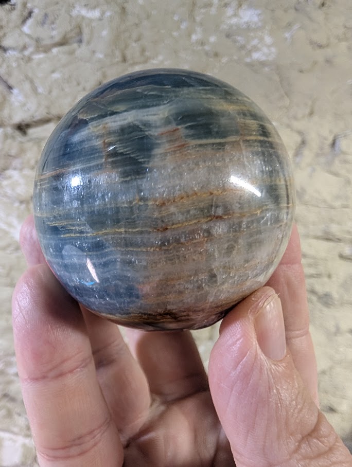 Front view of 63mm blue onyx sphere with banded patterns