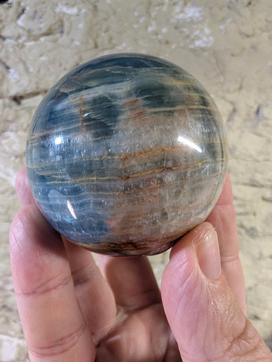 Front view of 63mm blue onyx sphere with banded patterns