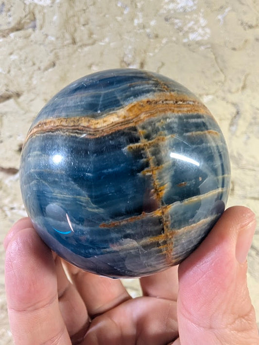Front view of 72mm Argentinian blue onyx sphere with cross-banding