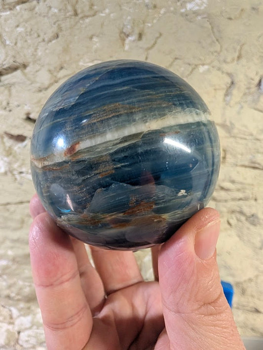 Front view of blue onyx sphere with wide white calcite band