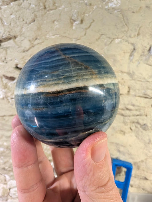 Blue calcite sphere showing white band near top edge and polish detail
