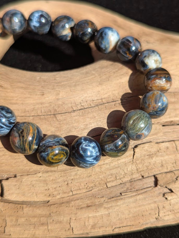 Macro shot of 10mm Blue Pietersite beads displaying the complex interlocked crocidolite structures unique to the Tempest Stone.