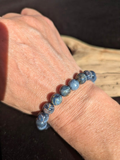 9mm AAA Grade Namibian Blue Pietersite beaded stretch bracelet worn on a wrist in natural light.