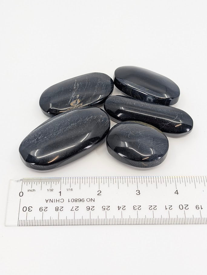 Blue Tiger Eye Palm Stones beside ruler for scale