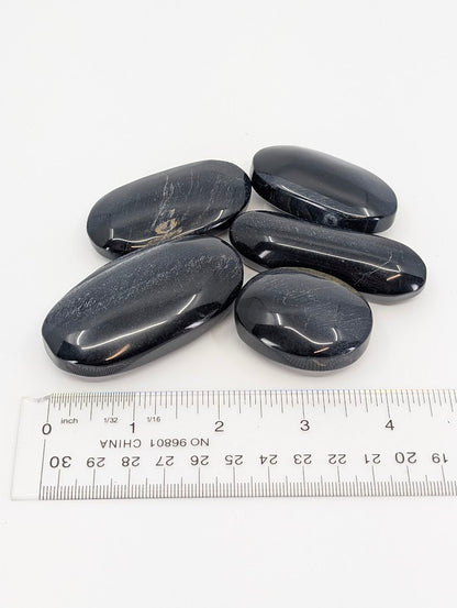 Blue Tiger Eye Palm Stones beside ruler for scale