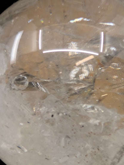 Extreme macro close-up of the internal negative crystal cavity and fluid inclusion within a 93mm Brazilian clear quartz enhydro sphere.