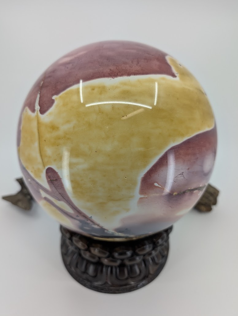 Detailed view of the natural mosaic pattern in the yellow brecciated section of a Mookaite sphere.