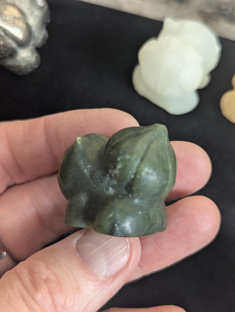 Top down view of a hand-carved Bulbasaur focusing on the natural stone texture.