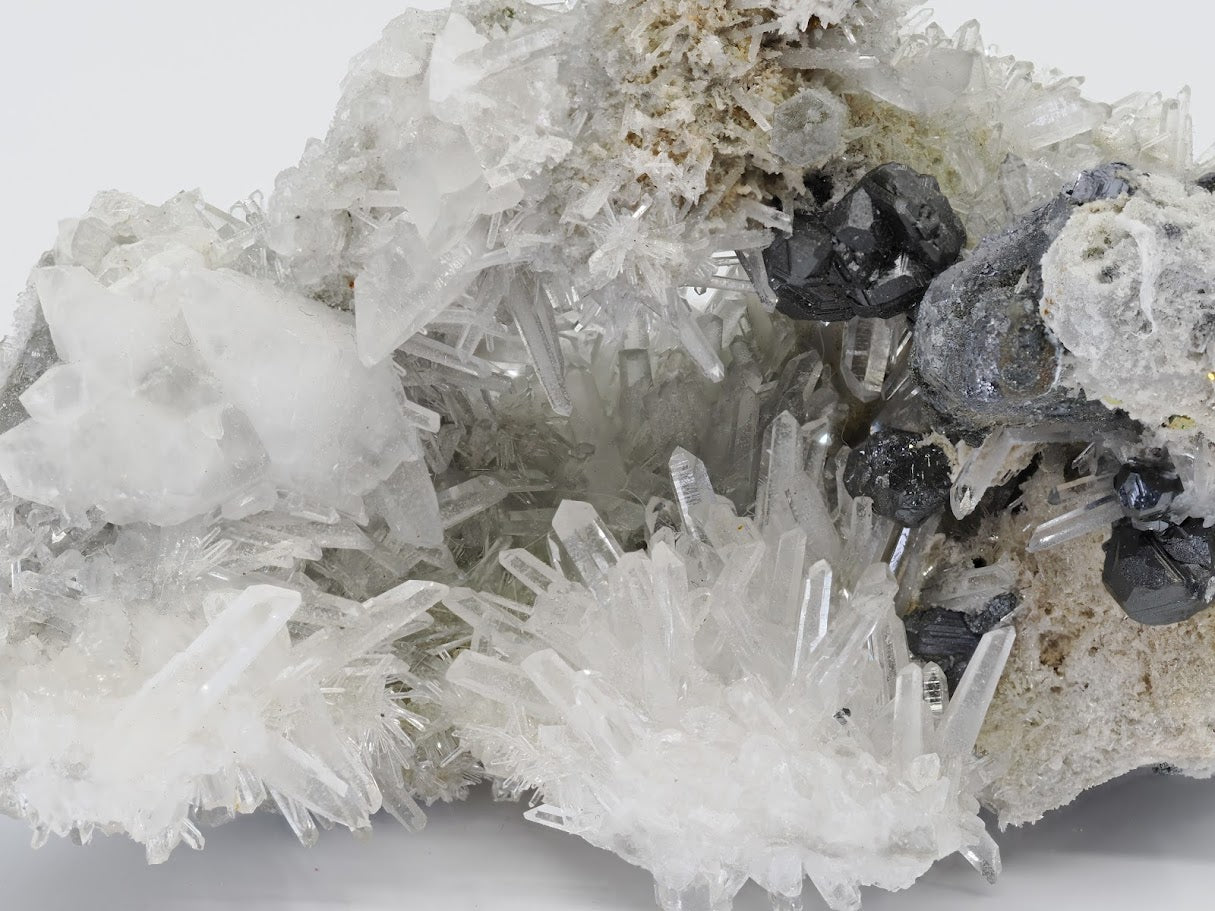 Side profile view of Burmese mineral specimen showcasing the depth of the galena base and projecting quartz needles.