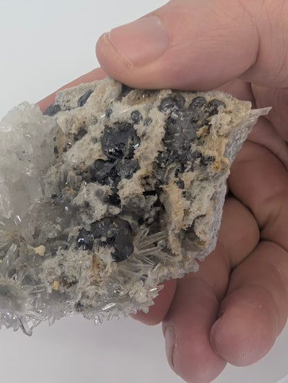 Cabinet display angle of a Burmese sulfide mineral specimen with needle quartz.