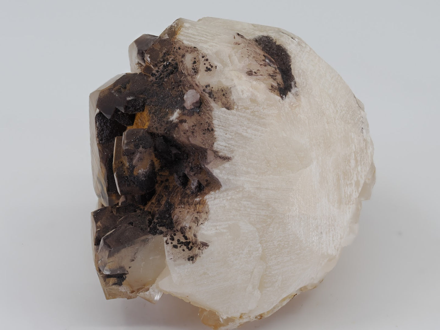 Base view of Calcite specimen showing white matrix attachment and natural rhombohedral cleavage planes.