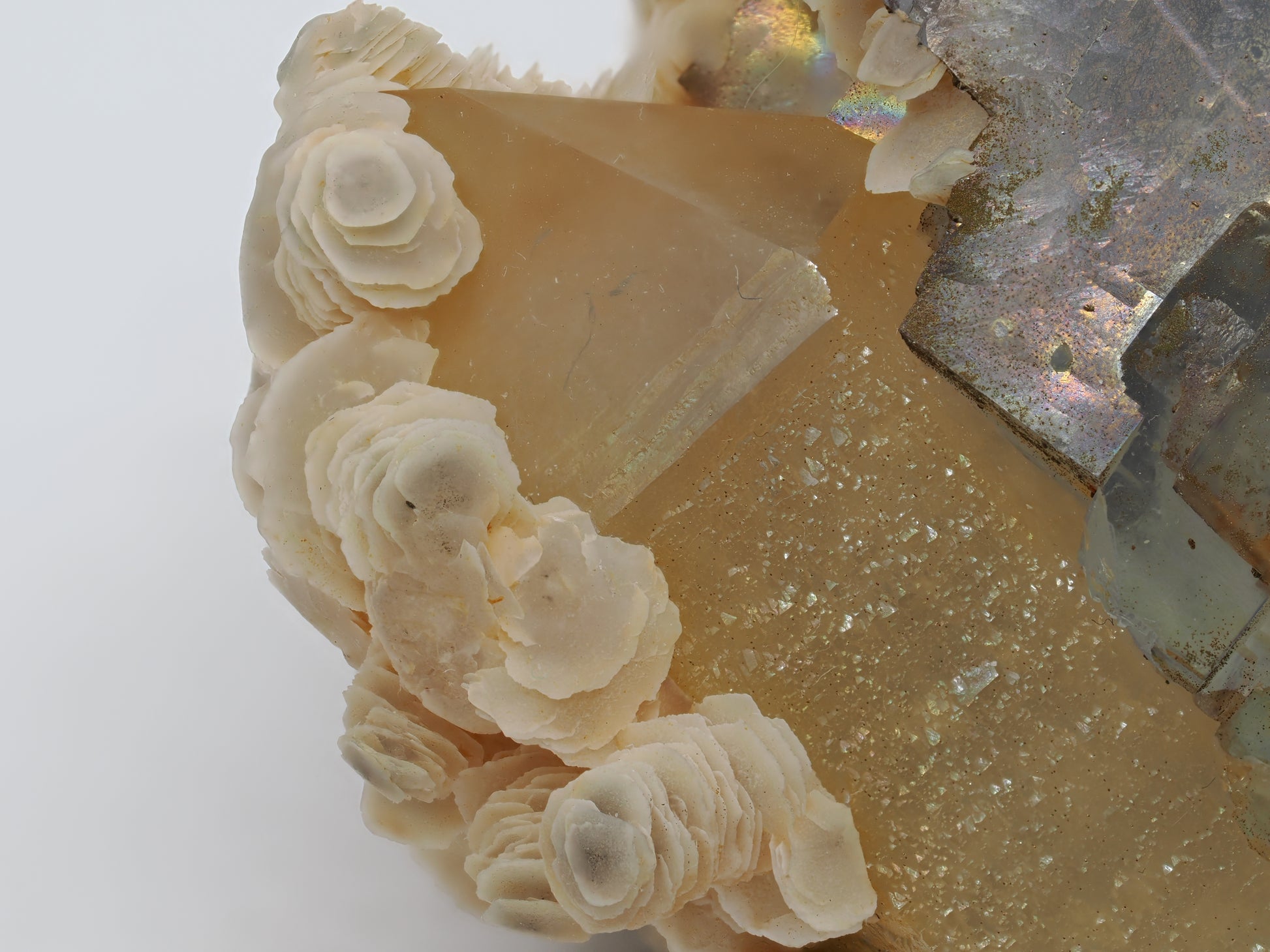 Extreme close-up showing the growth interface of stacked Calcite blades attached to a transparent Quartz crystal.