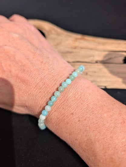 Natural sunlight on a 4mm pastel blue Caribbean Calcite stretch bracelet worn on a wrist.