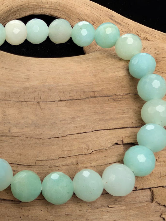 Macro close-up of 8mm faceted HQ Caribbean Calcite beads highlighting the geometric cut and the natural mix of blue calcite and white aragonite.