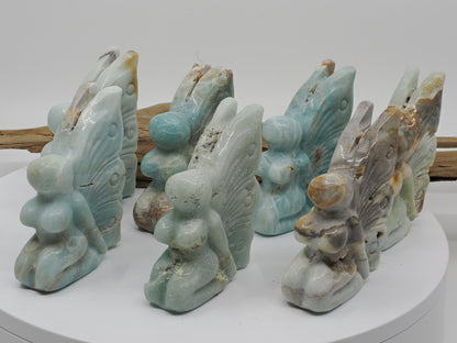 Group display of seven Caribbean Calcite Butterfly Fairy carvings showing variety in color and banding.