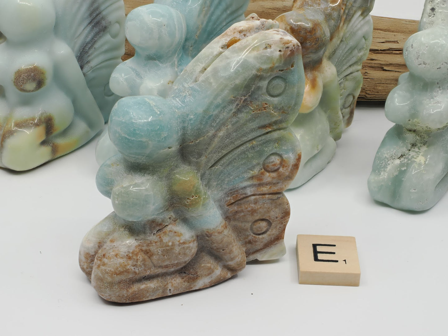 Caribbean Calcite butterfly fairy E with sandy tan aragonite base and blue wing tips.