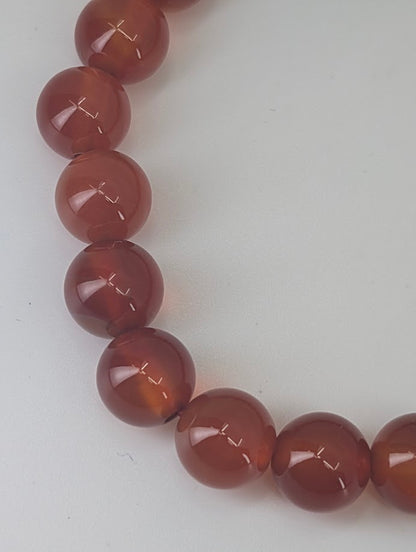 Stack of AAA Carnelian bracelets demonstrating uniform tone and warm amber-red hue