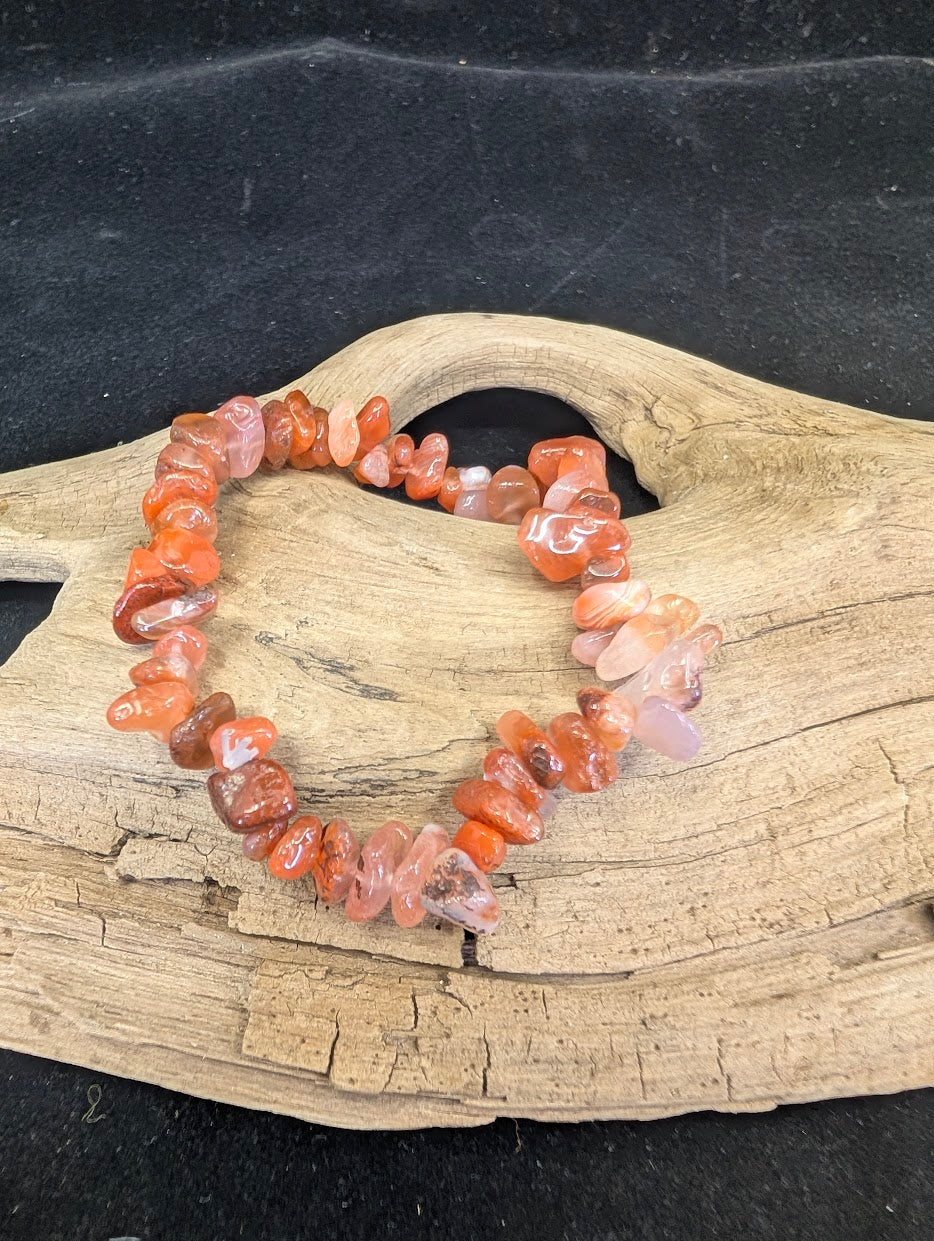 Full view of a Carnelian chip bracelet featuring vibrant orange and sunset-toned polished crystal shards on a natural driftwood base.