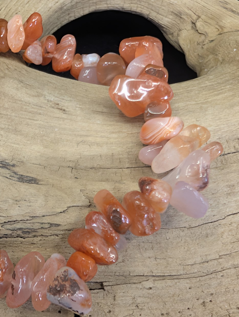 Close-up detail of polished Carnelian chips highlighting natural banding, translucency, and rich iron-oxide coloration.